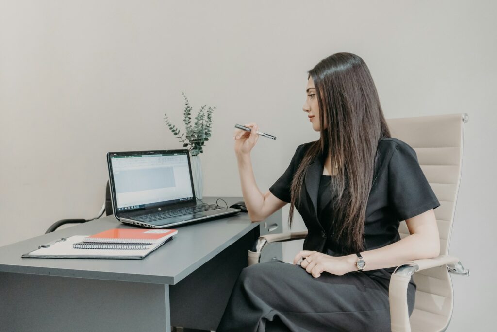 Woman working at a desk with a laptop.