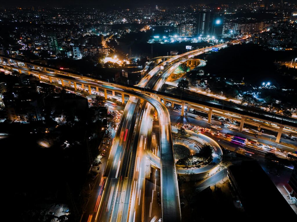 A stunning aerial photograph capturing a bustling city interchange illuminated at night.