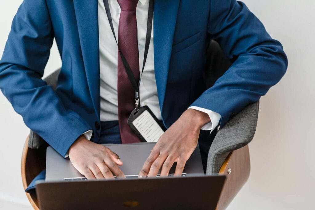 Top view of a businessman in a blue suit using a laptop in a modern office.