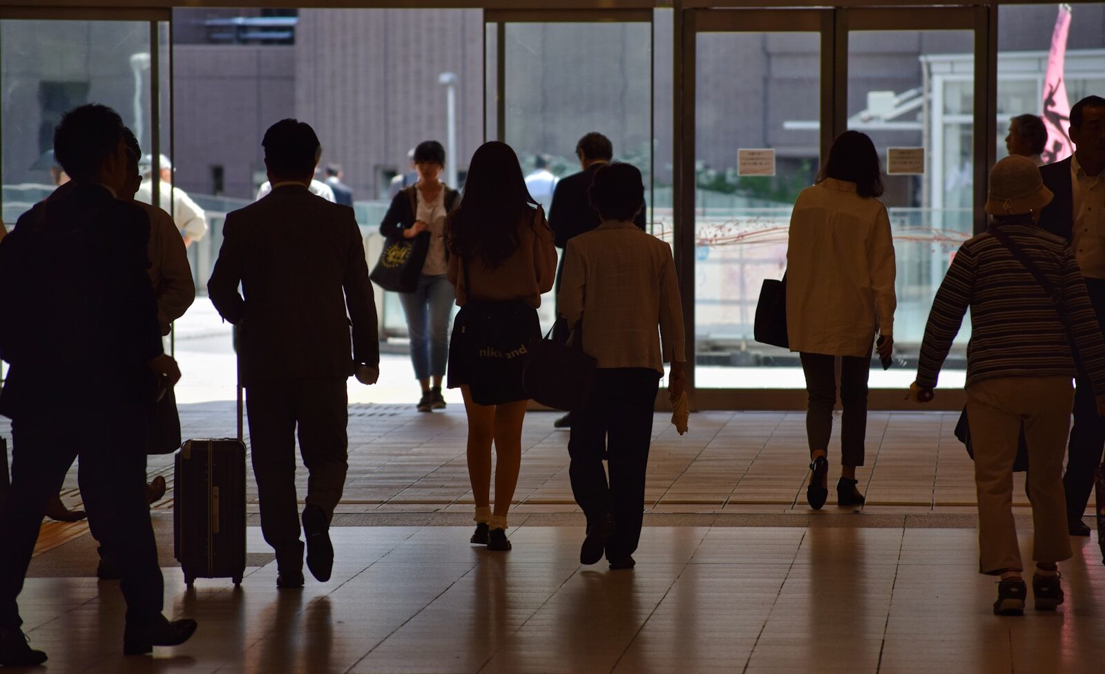 a group of people walking through a lobby