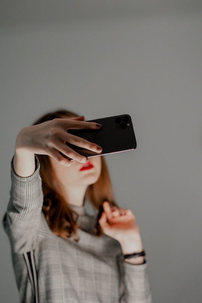 How AI and New Digital Tools Are Being Used to Control, Harass, and Silence Women a person holding a phone