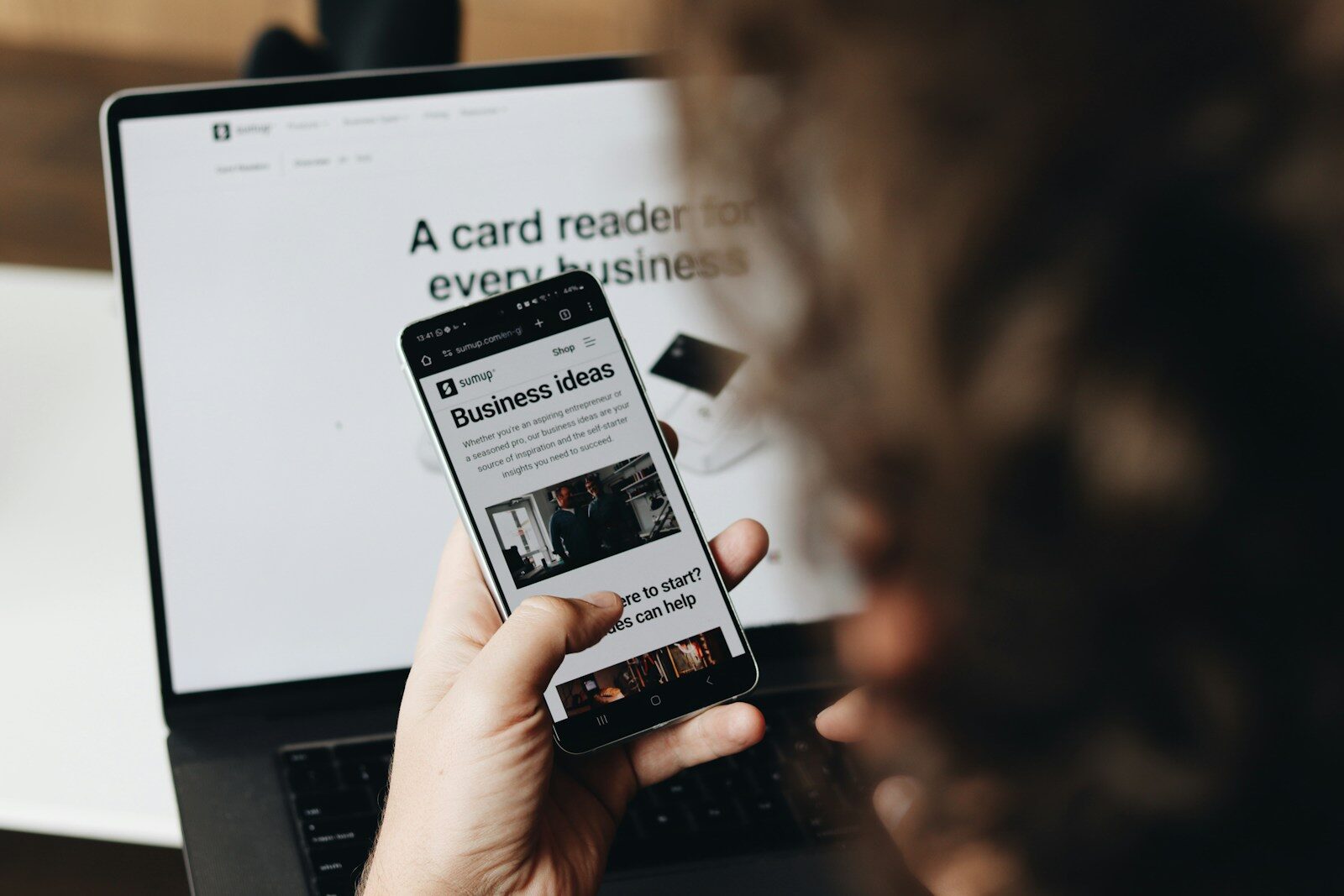 The AI Productivity New Begun and Economic Finally Showing Up A person holding a cell phone in front of a laptop
