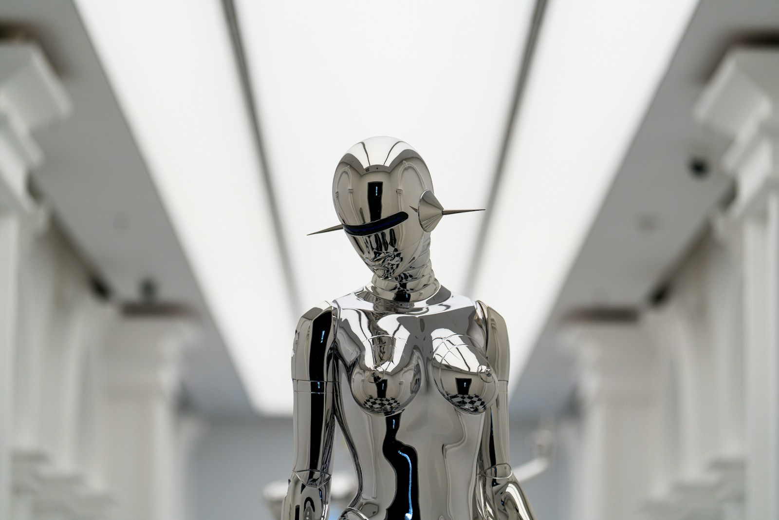 A futuristic silver sculpture stands.