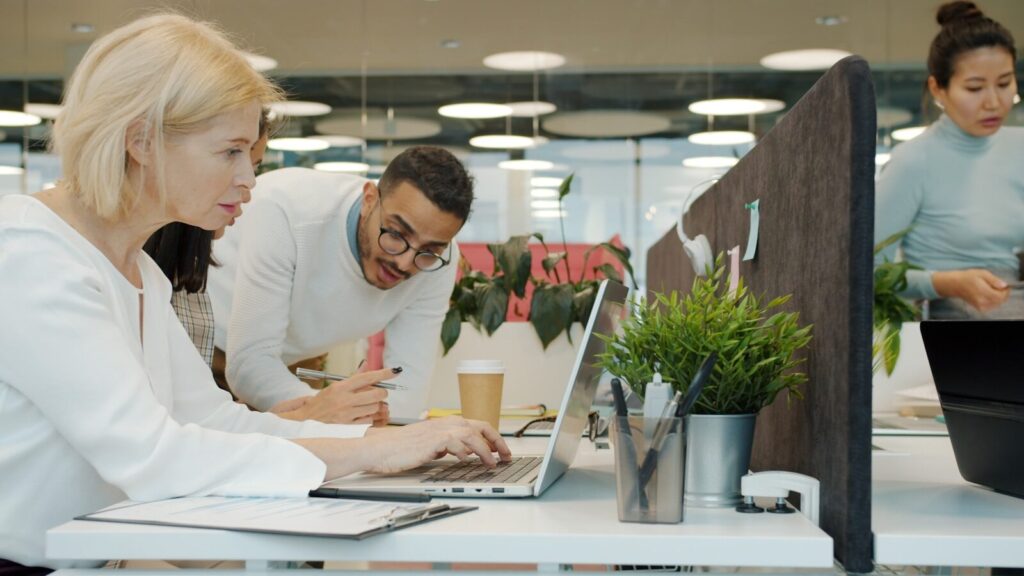 Colleagues collaborating on a project at office desks.