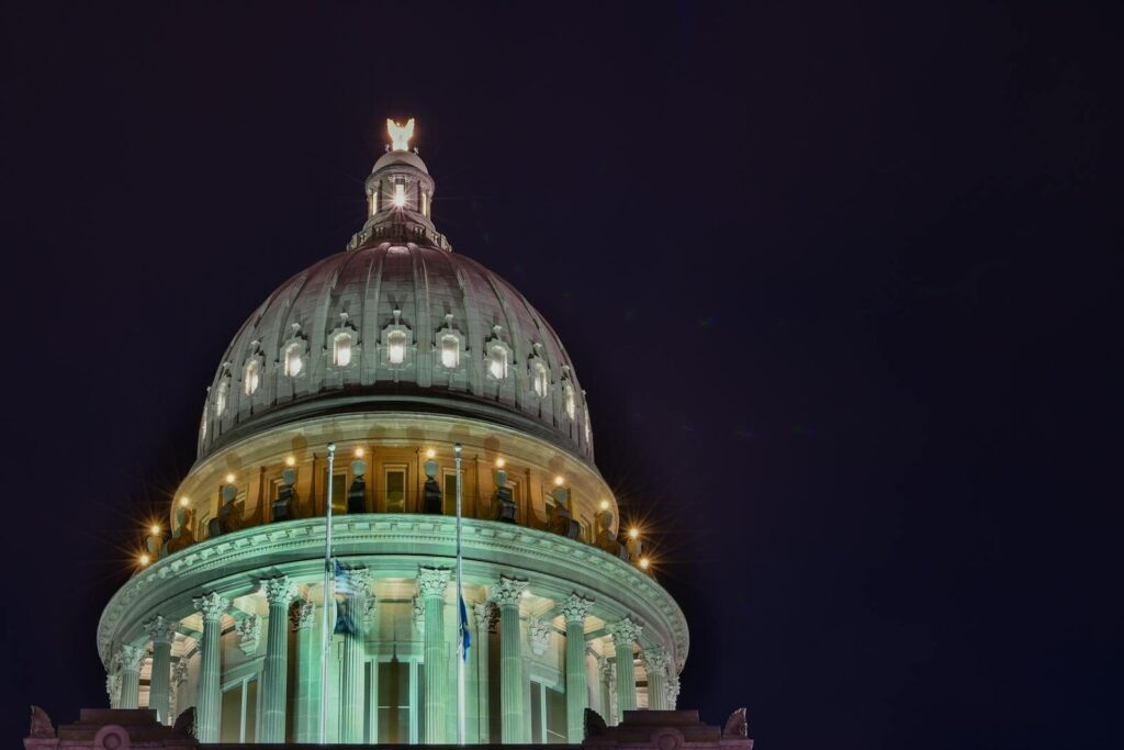 A stunning view of an illuminated capitol building dome against the night sky.