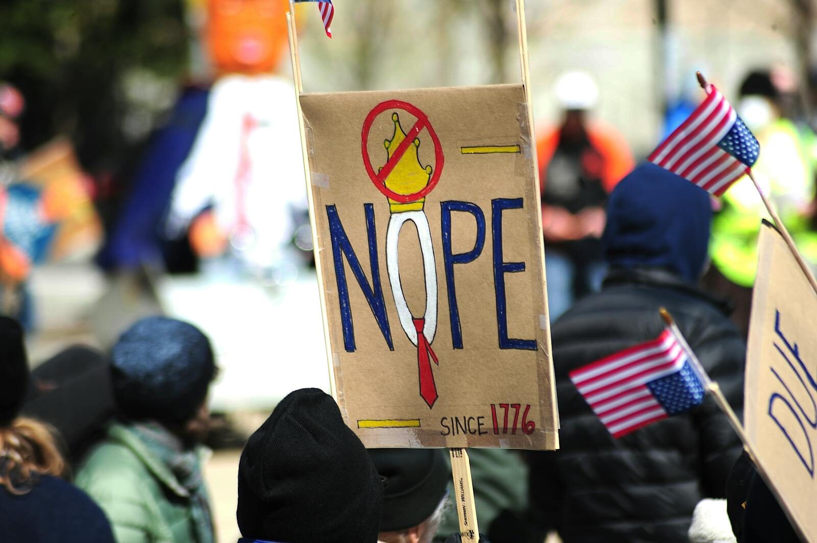 Why Tech CEOs Pointing AI New Reason Behind Mass Layoffs Participants hold anti-monarchy signs at a protest in Baltimore, USA, expressing political sentiments.