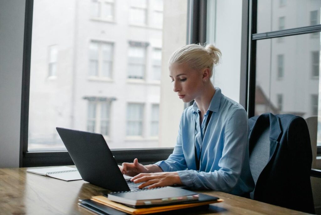 Professional woman working diligently on her laptop in modern office setting.