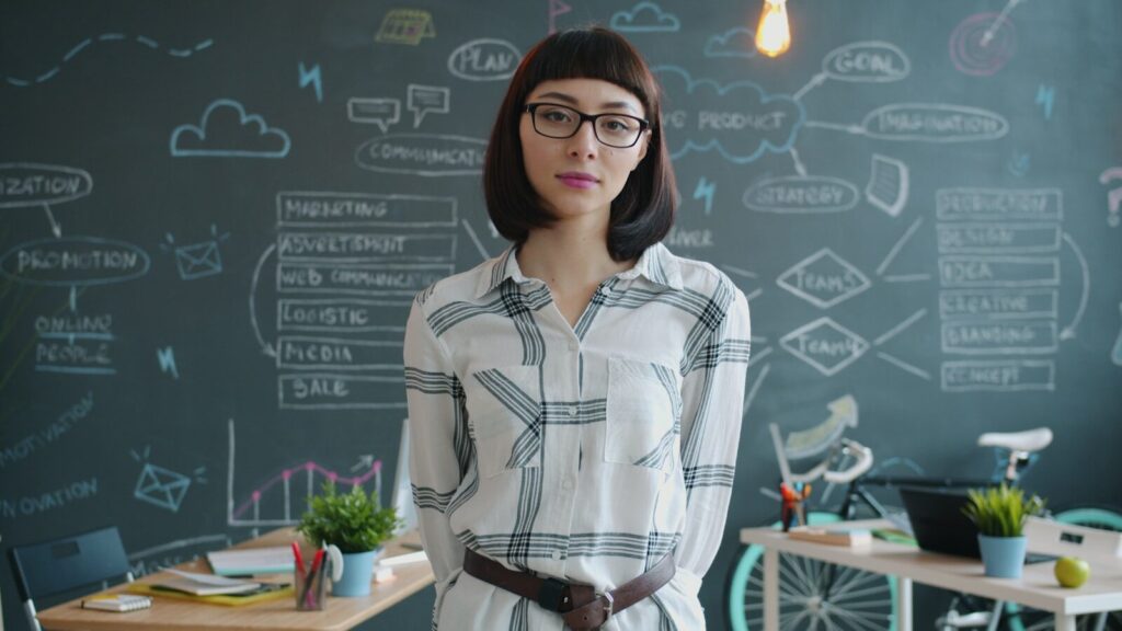 How AI Is Empowering a New Generation of Blue-Collar Entrepreneurs Woman standing in front of a chalkboard with diagrams