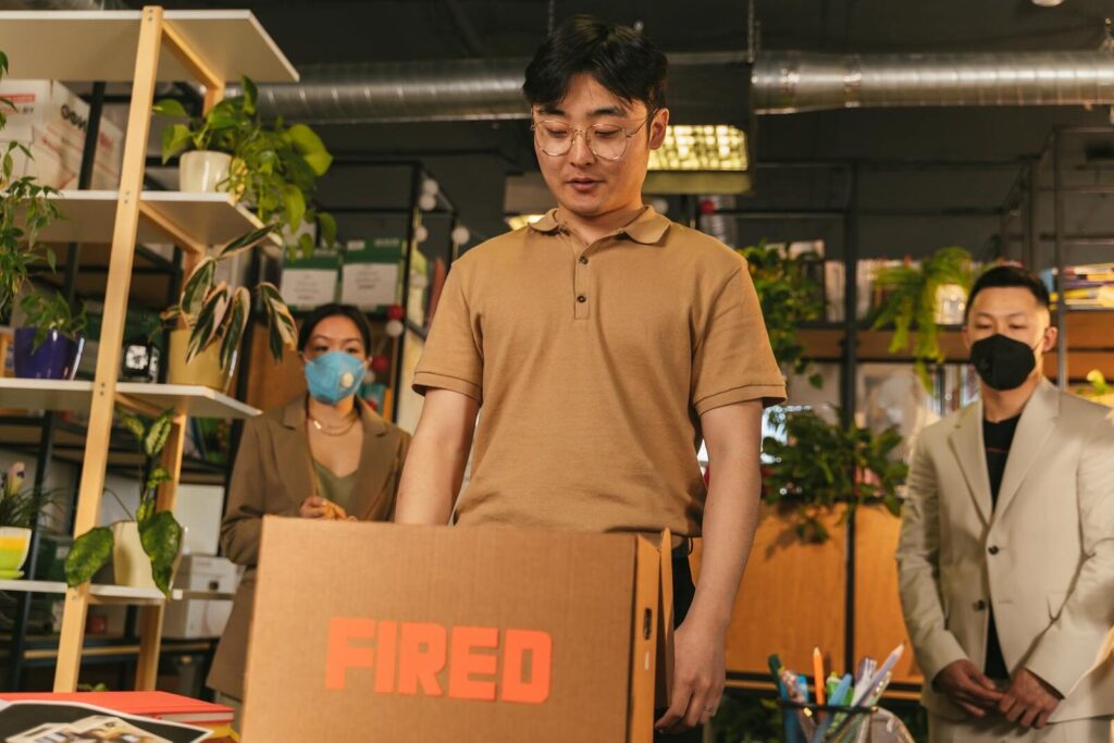 Man standing by cardboard box labeled 