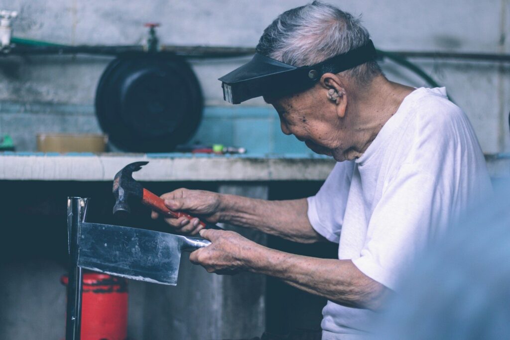 man in white t-shirt holding black metal tray