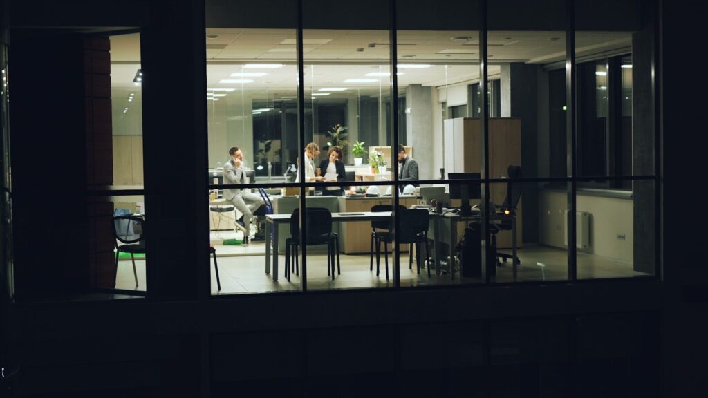 How Workplace Surveillance Software Redefining New Trust, Productivity and Privacy People working late in a modern office at night.
