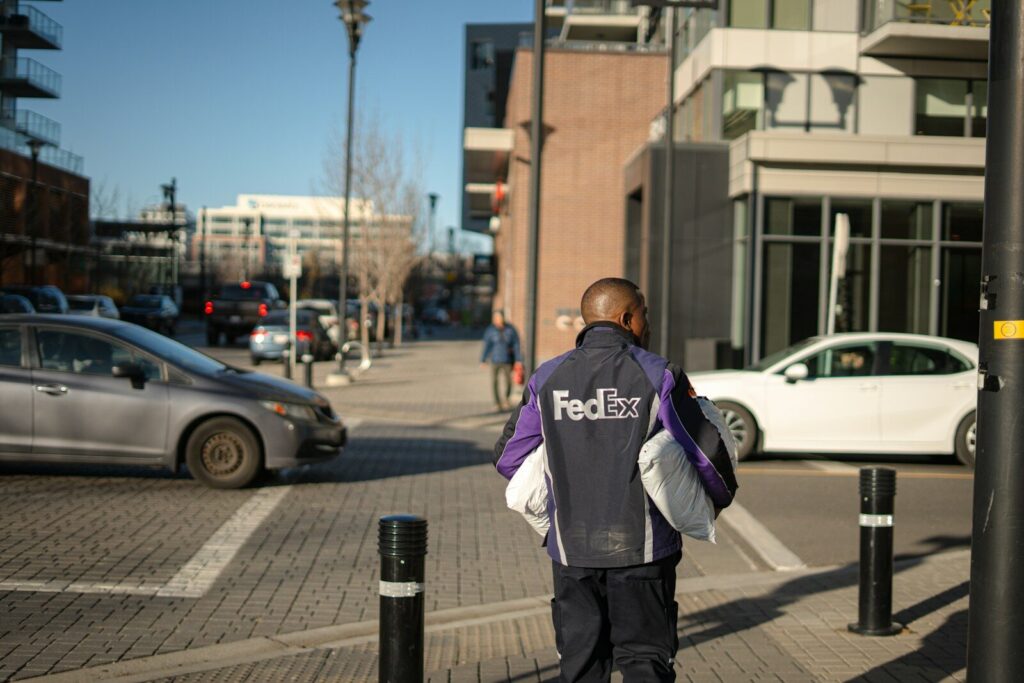 How Intelligent Agents Transform Global Logistics and New Future Work Fedex delivery person walking down city street