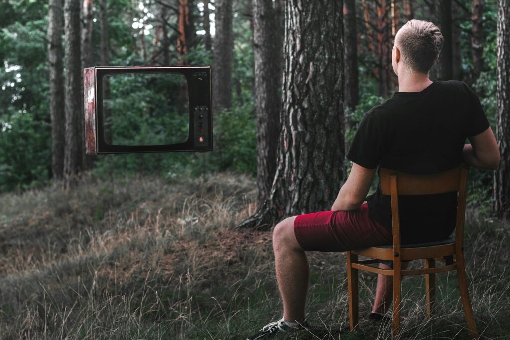 man in black t-shirt sitting on brown wooden chair