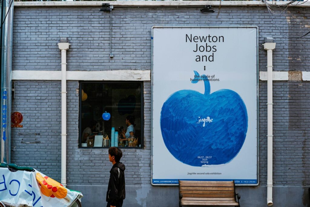 A person walks by a newton jobs billboard.