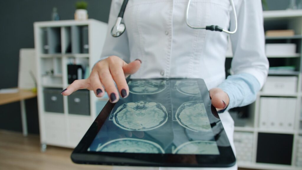 Doctor shows brain scan on tablet in office