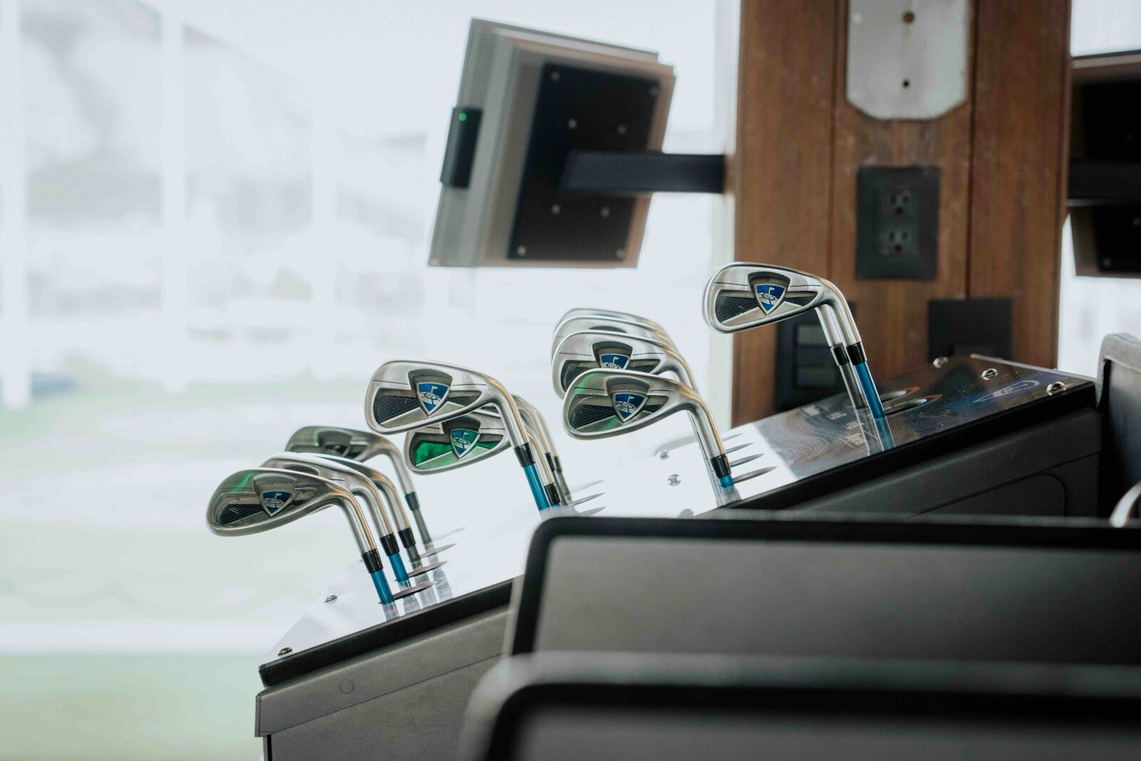 Golf clubs rest in a display.