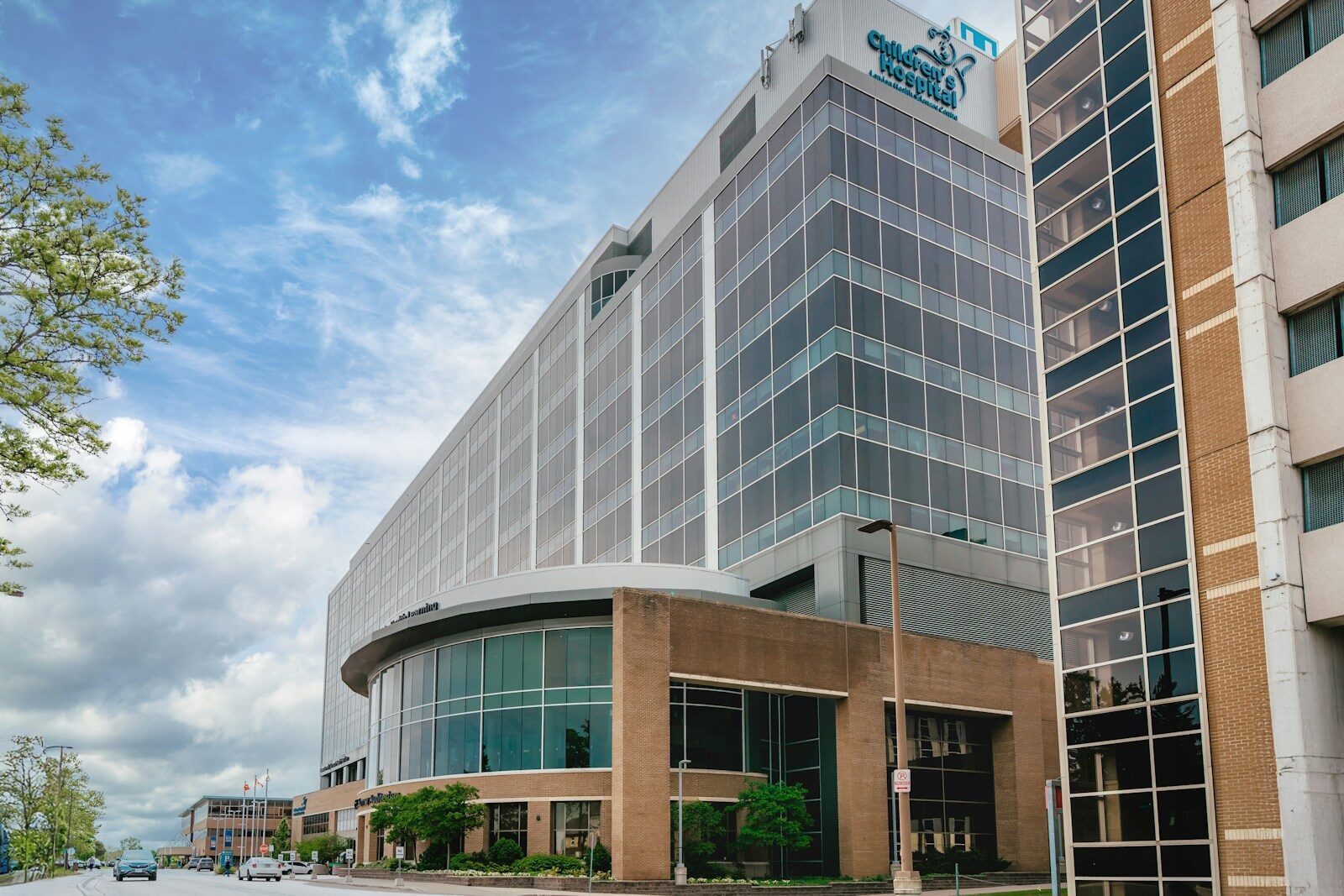 Modern glass building with curved entrance under sky.
