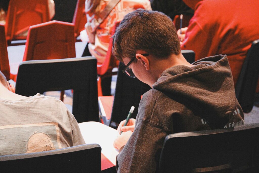 Why Removing New Chatbots From Classrooms May Be Impossible A boy sitting in a chair writing on a piece of paper