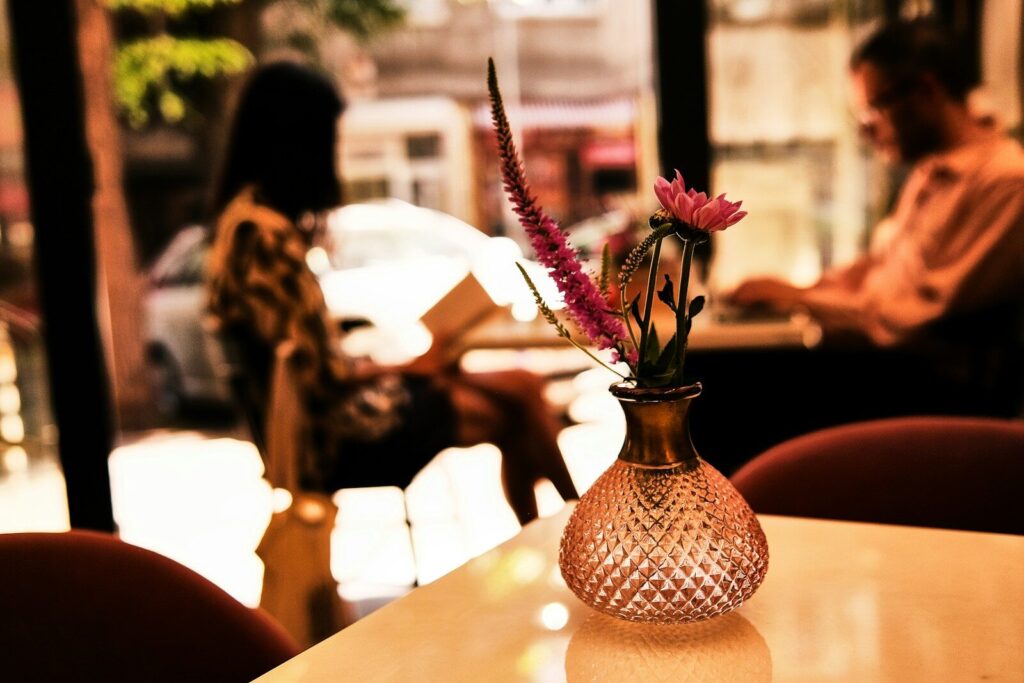 pink and white flowers in brown ceramic vase on table