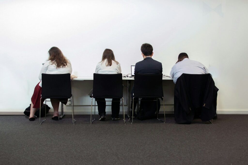 Why Removing New Chatbots From Classrooms May Be Impossible a group of people sitting at a table in front of a white wall