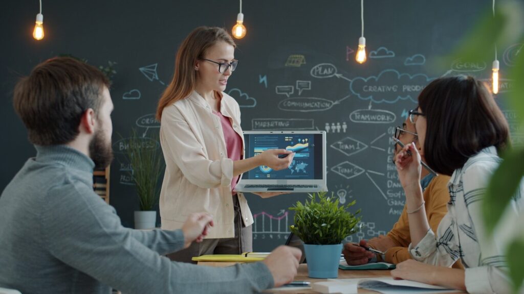 How New Business Model Is Turning Software Autonomous Work Engines Woman presenting a business strategy to colleagues