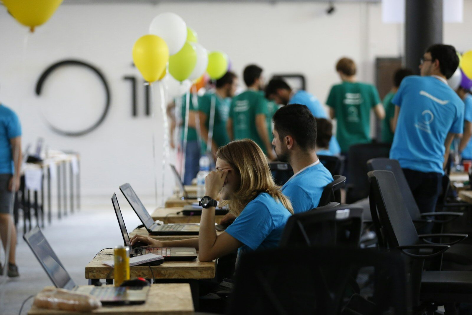 a group of people working on laptops in a room