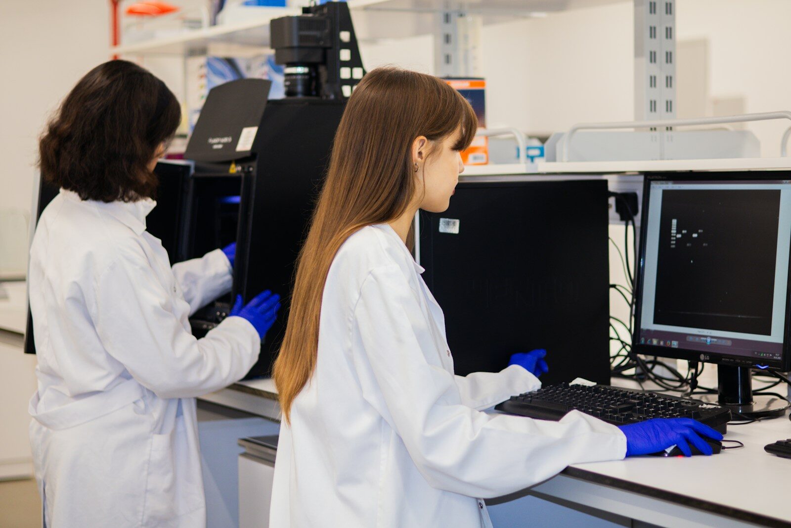Two scientists working on computers in a laboratory.
