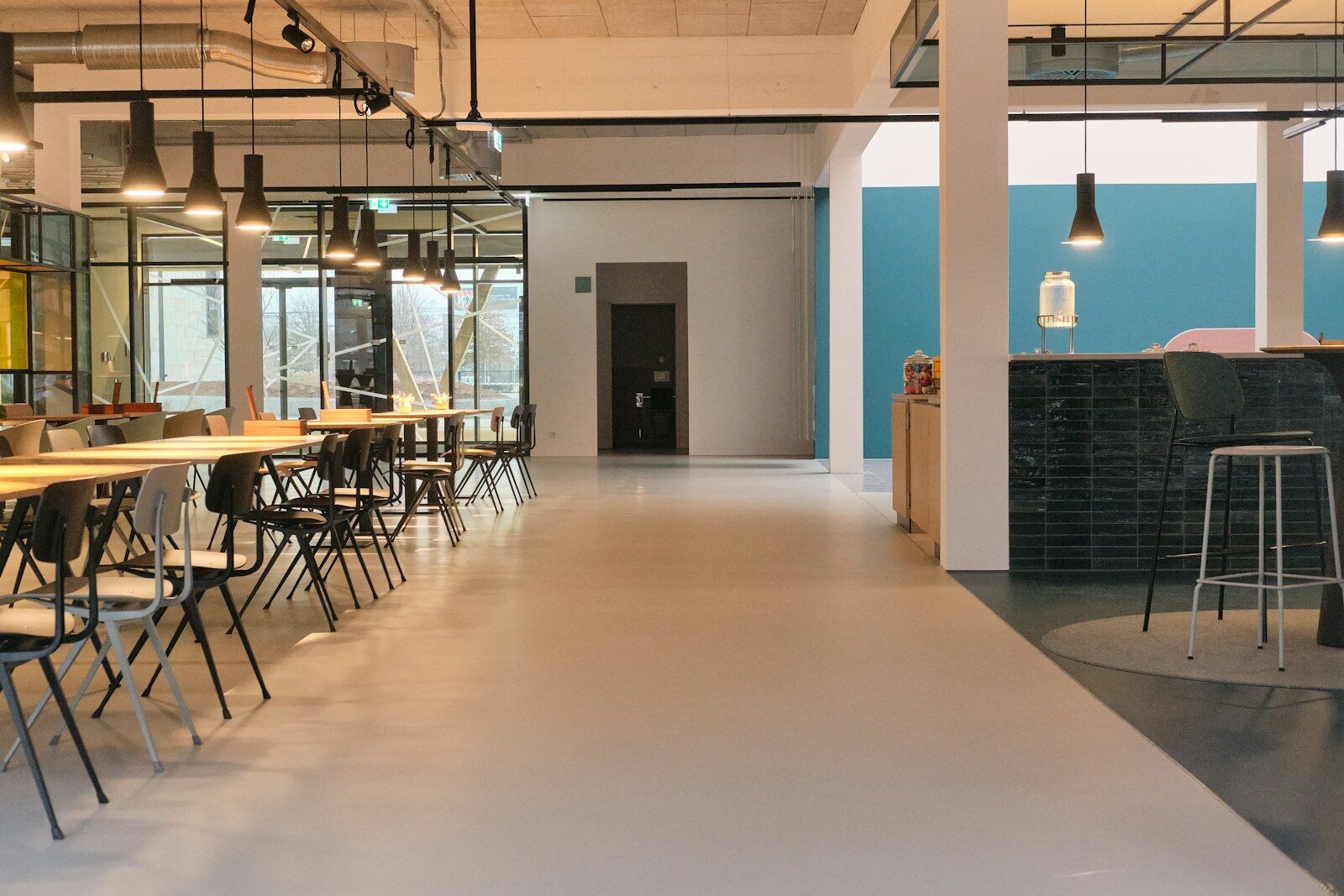 Modern office space with long tables and chairs.