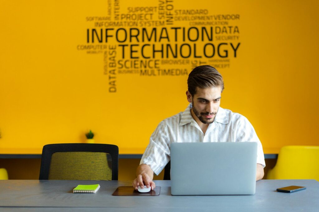 Why Tech Giants Cutting Jobs While Spending Billions New AI a man sitting in front of a laptop computer