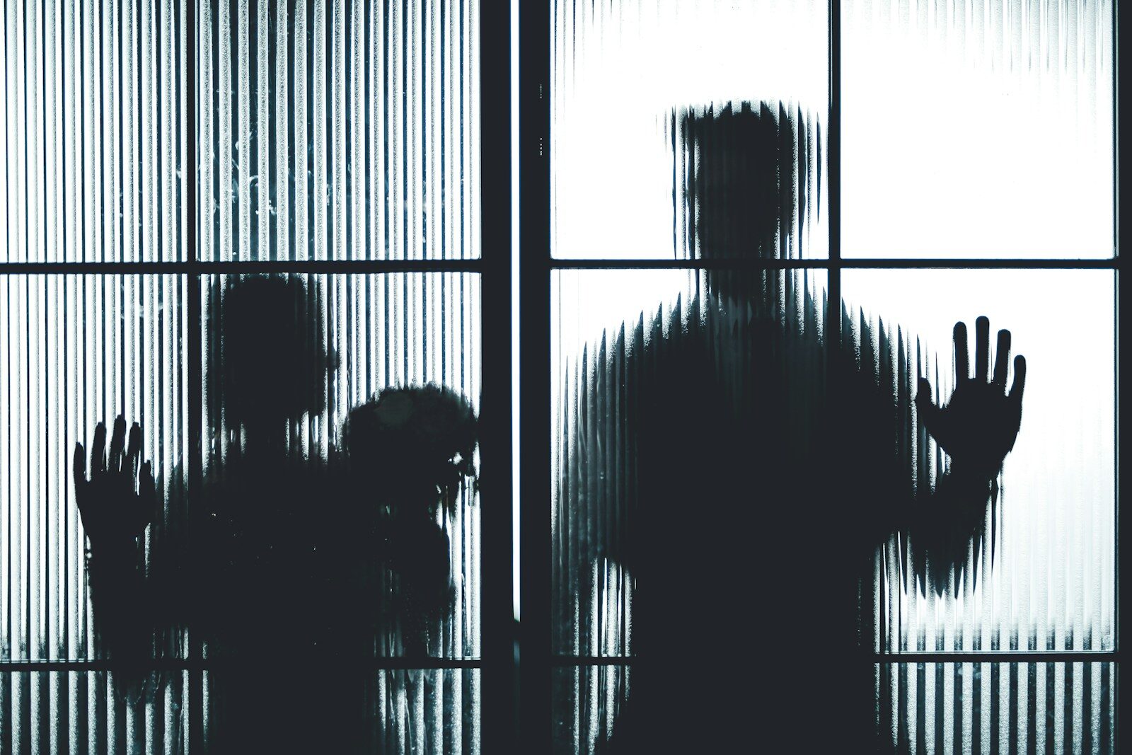 silhouette of people standing in front of window
