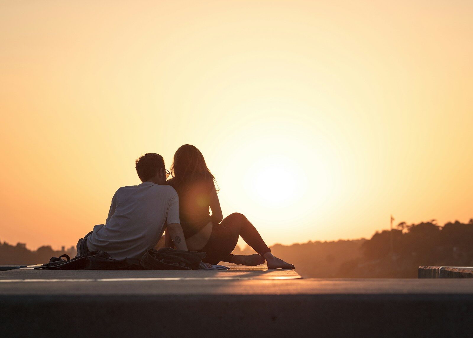 Inside Quiet Relationship Crisis Emerging in the Shadow of AI couple sitting near trees during golden hour