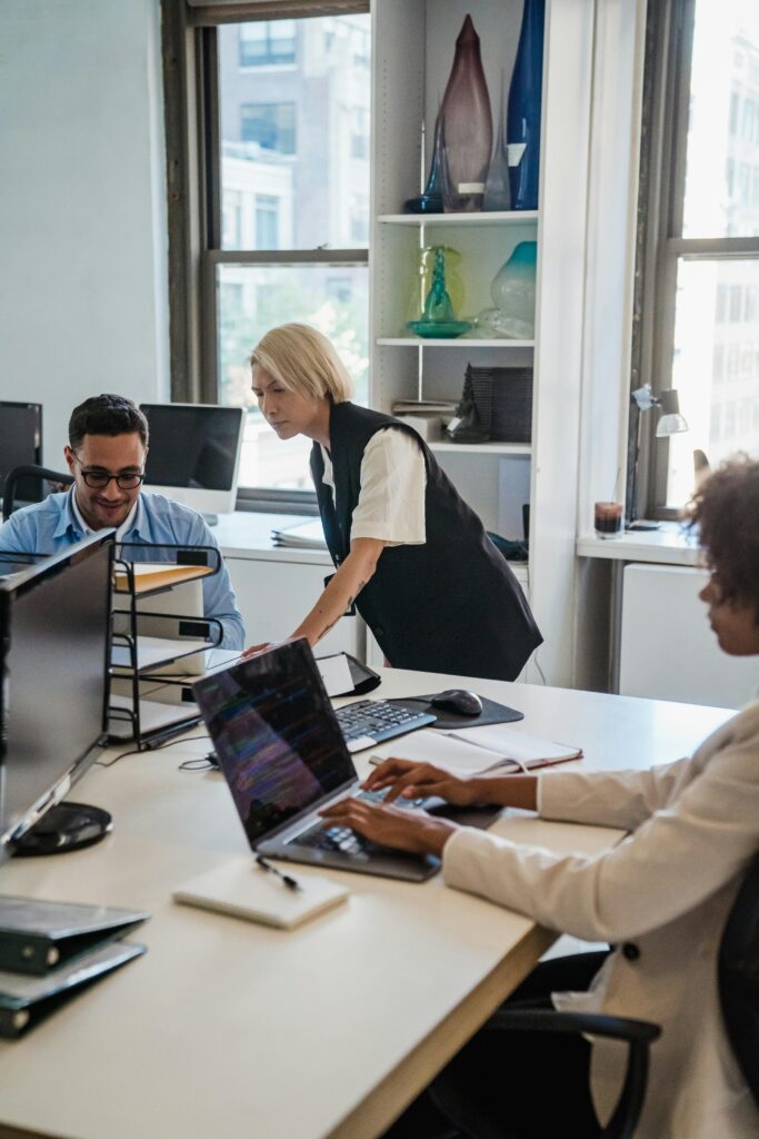Professionals working collaboratively in a contemporary office environment with laptops and documents.