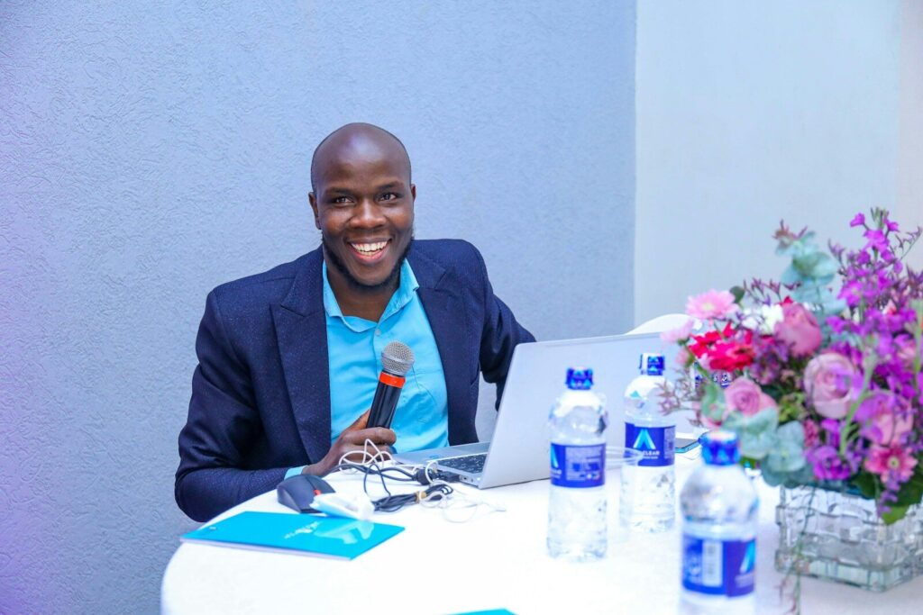How Kenya’s Digital Health Revolution Is Pricing Out the Poor A man sitting at a table with a laptop
