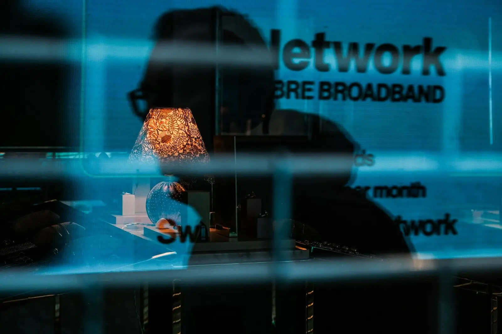 AI Replacing New Jobs But Cybersecurity Experts Are More Valuable Than Ever a reflection of a lamp in a glass window