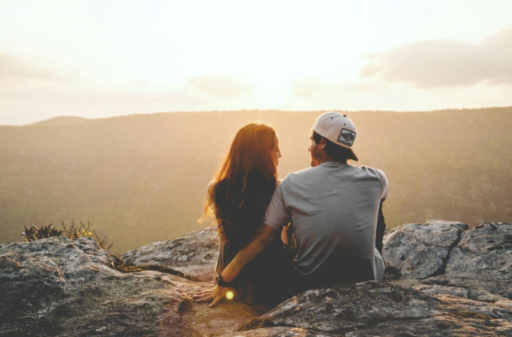 Inside Quiet Relationship Crisis Emerging in the Shadow of AI man and woman sitting on rock during daytime