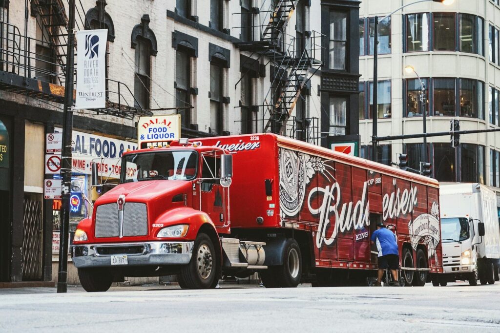 Why Americans Fear New AI More Than Ever And That not Irrational man near red Budweiser trailer truck parked near concrete building during daytime