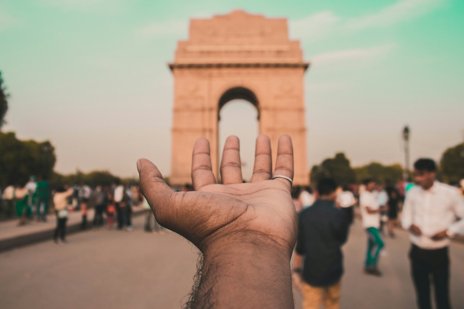 person holding brown concrete arch