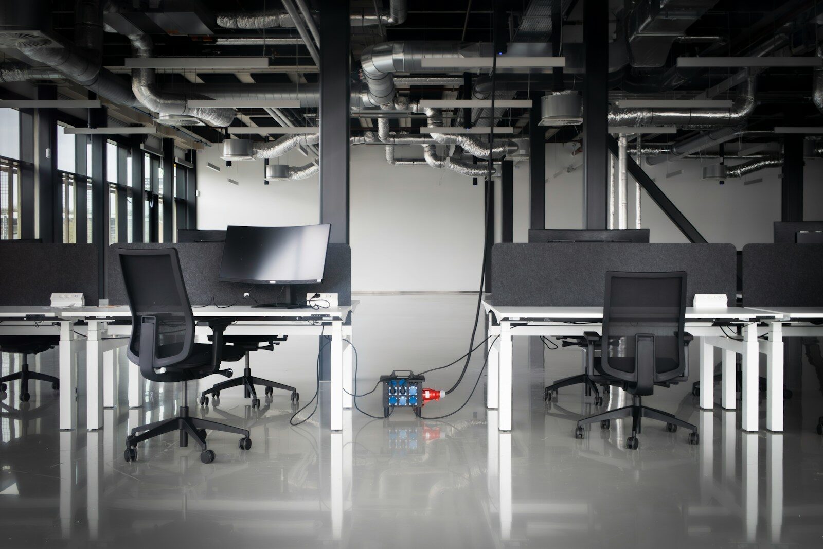 AI Is Transforming the New Workplace Faster Than Ever Modern office with desks, chairs, and exposed pipes.