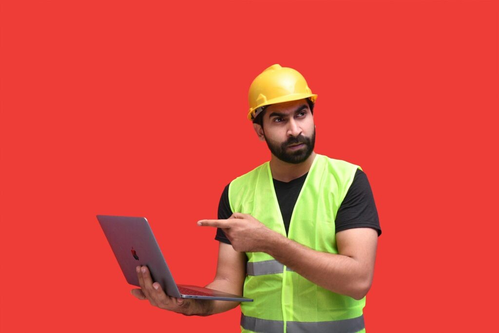 Why AI Companies Increasingly Restricting Their Most New Powerful Models a man wearing a hard hat and holding a laptop