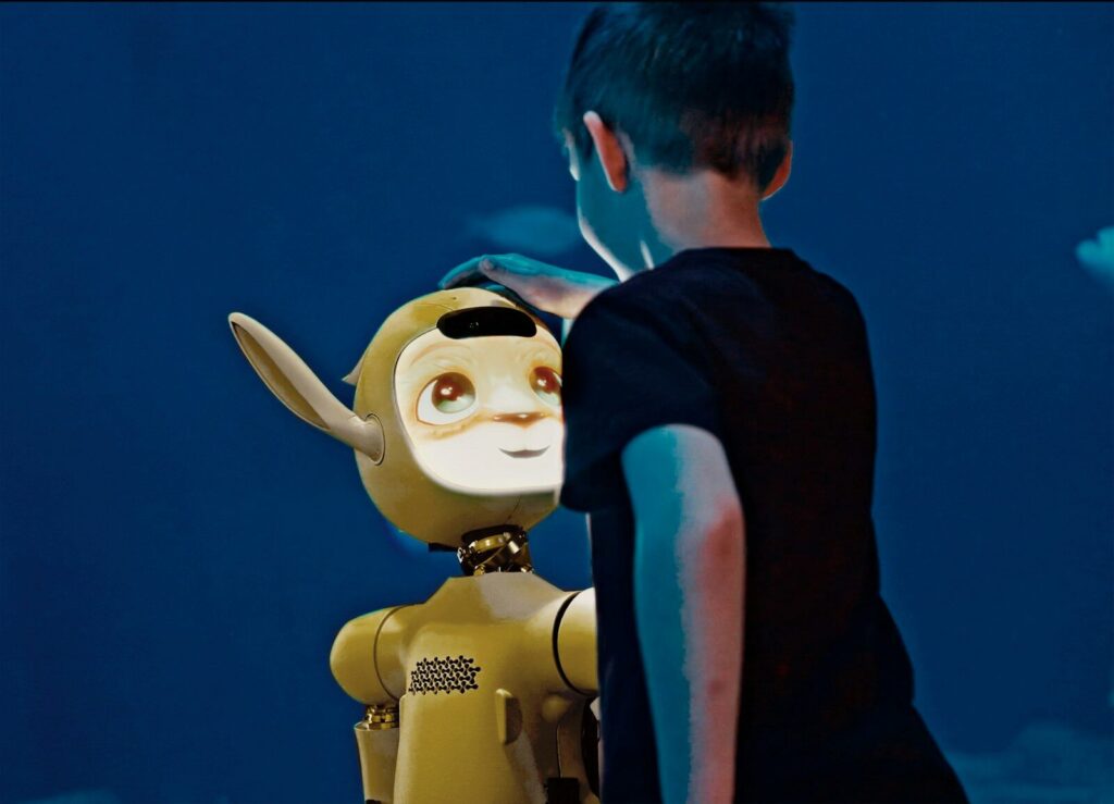 What the Next Decade of New AI Could Look Like A young boy gently pats a yellow robot's head.