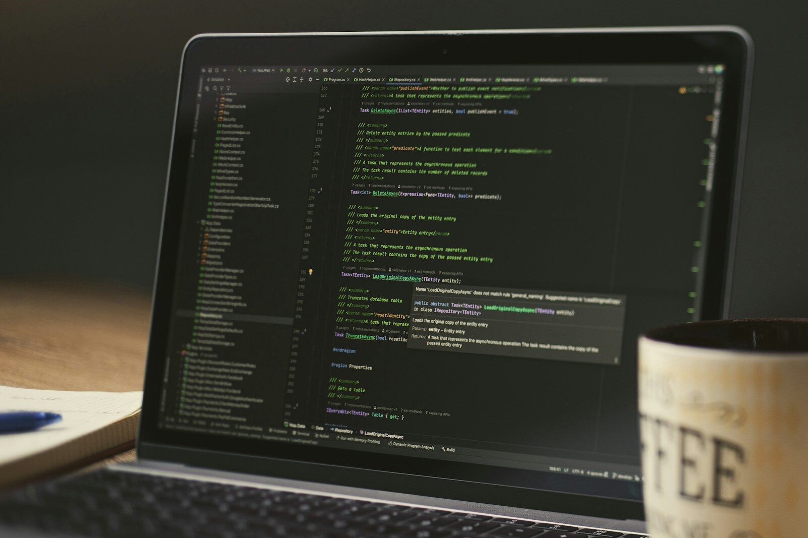 Laptop screen displaying lines of code with a coffee mug.