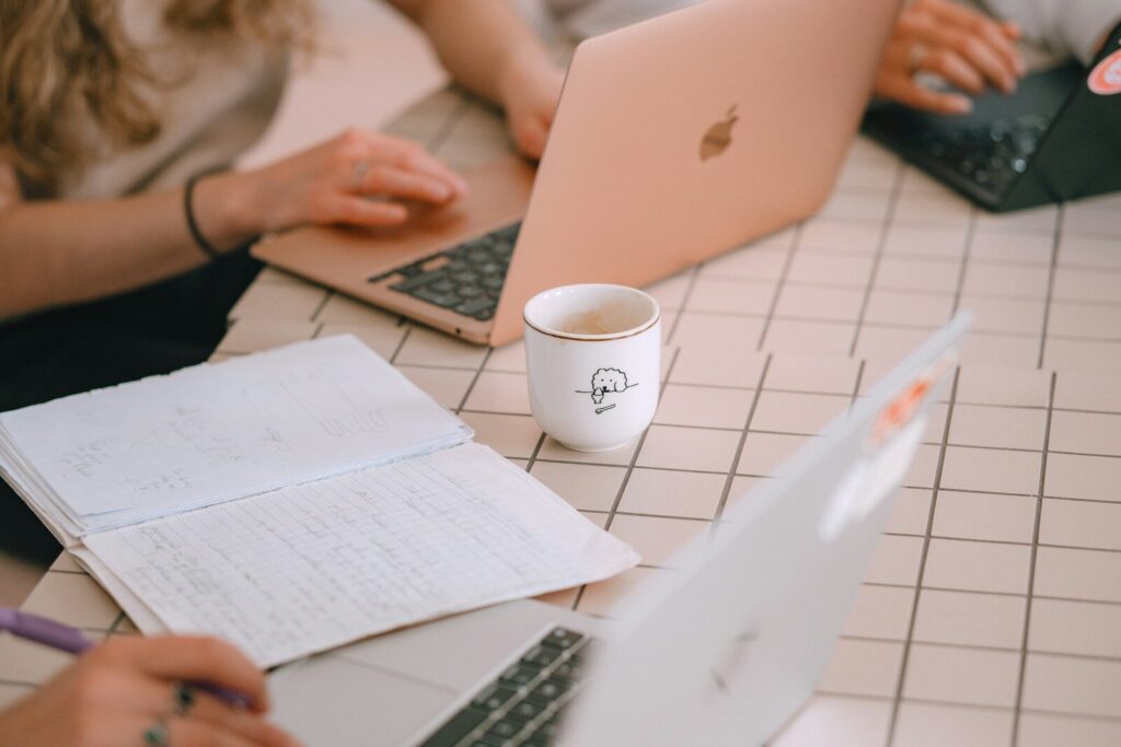 AI Will Create More New Jobs Than It Replaces People working on laptops with notebooks and notebooks.
