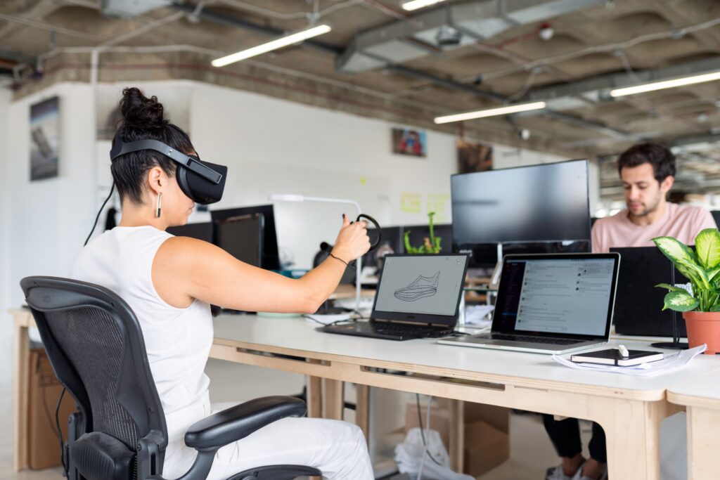 The Growing Debate Over Employee Tracking in New Digital Workplace Woman using virtual reality headset in a modern office for design and innovation.
