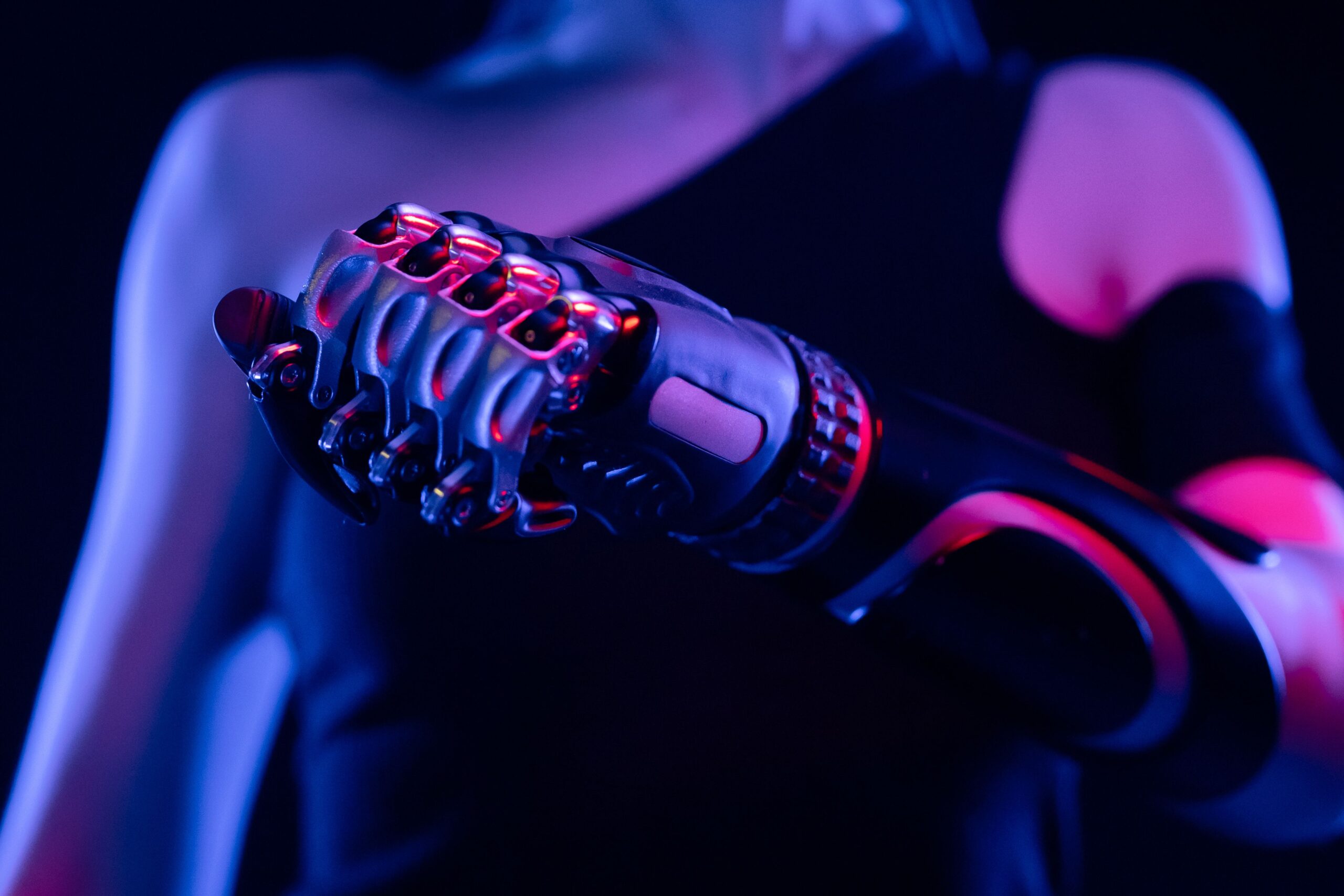 How Wearable Robotics Are Transforming New Human Work and Mobility Close-up of a robotic prosthetic hand in neon lighting, symbolizing advanced technology.