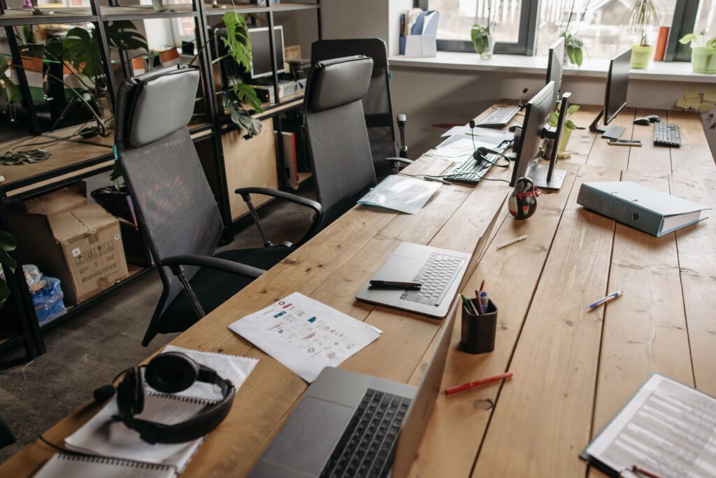 The Growing Debate Over Employee Tracking in New Digital Workplace Spacious co-working office with wooden desks, laptops, and modern chairs.