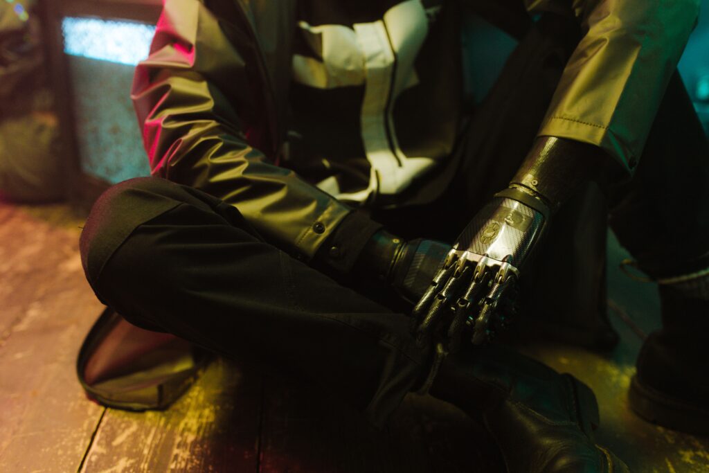 Person with a bionic prosthetic arm seated indoors with a modern look.