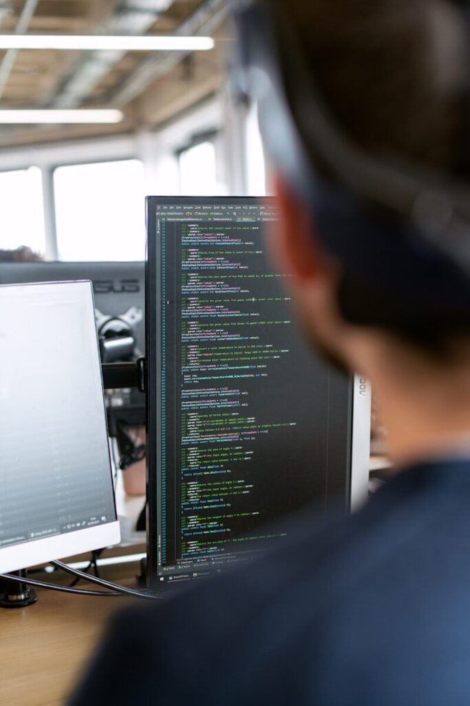 The Hidden Human Labor Powering the New AI Revolution man in black shirt sitting in front of computer monitor