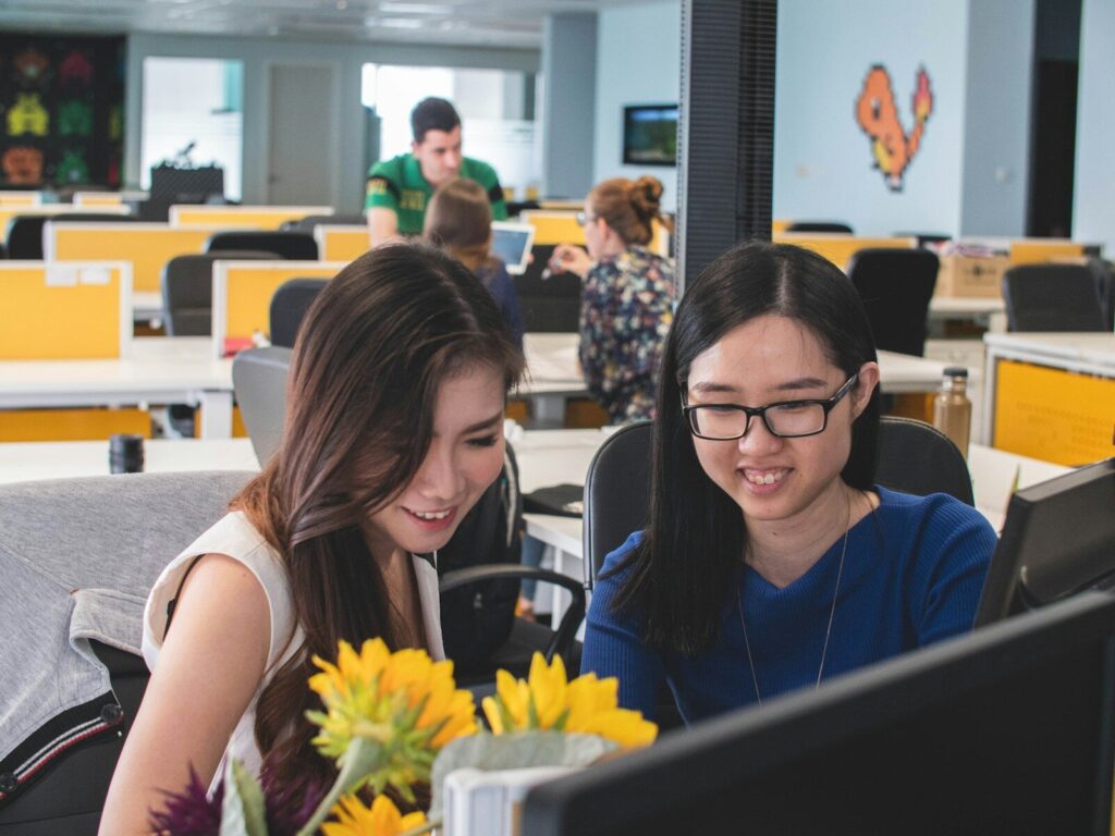 How AI Reshaping New Workforce Instead of Simply Replacing It selective focus photography of two women in front of computer monitor