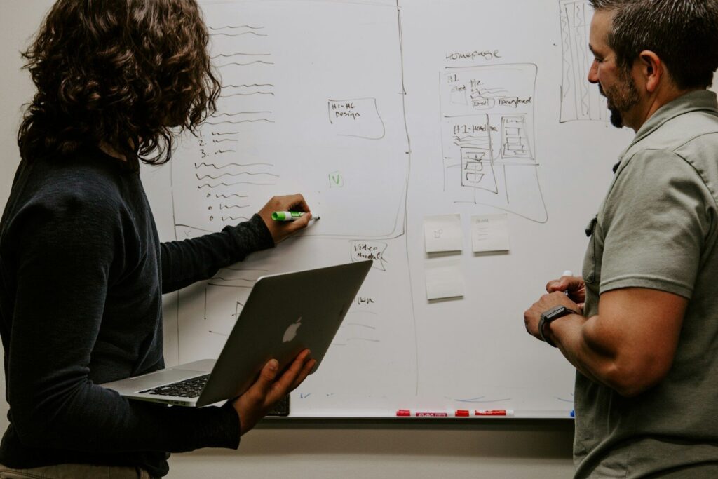 How Two Different AI Strategies Shaping New Future of AI man wearing gray polo shirt beside dry-erase board