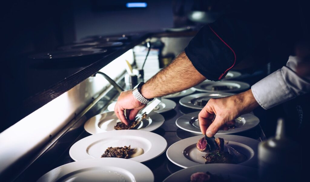 How Sodexo Using AI and Robotics Reinvent New Commercial Kitchens person preparing cooked dish